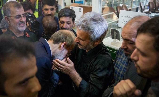 عکس بوسه دکتر لاریجانی بر دستان پدر شهید حججی